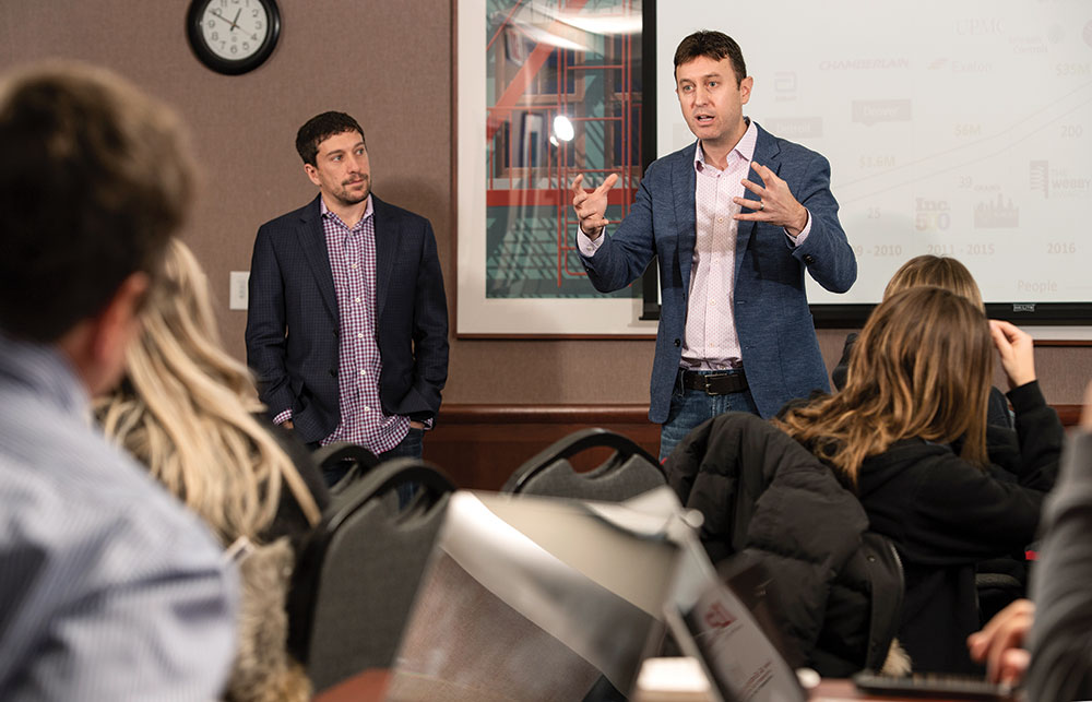 Brad Schneider (left) and Ross Freedman speak with student entrepreneurs