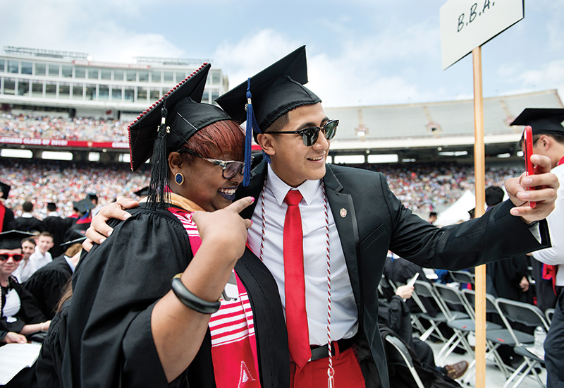 Vital (R) grabs a selfie with fellow graduate 
                                         Diamond Howard (MSW ’15) during the 2015 Class Spring Commencement at Camp Randall.