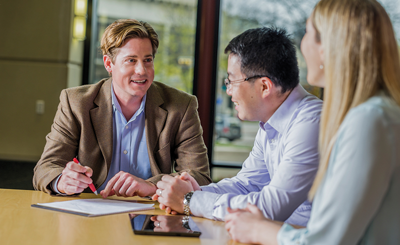 A male WSB professor talking with two students