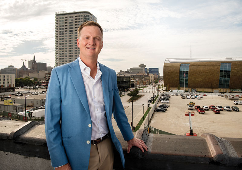 Blair Williams (B.A. ’94, MBA ’97, JD ’97, M.S. ’98) with downtown Milwaukee behind him