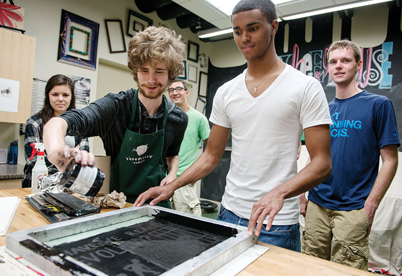 Wisconsin School of Business students create posters at Wheelhouse Studios in response to assigned reading.
