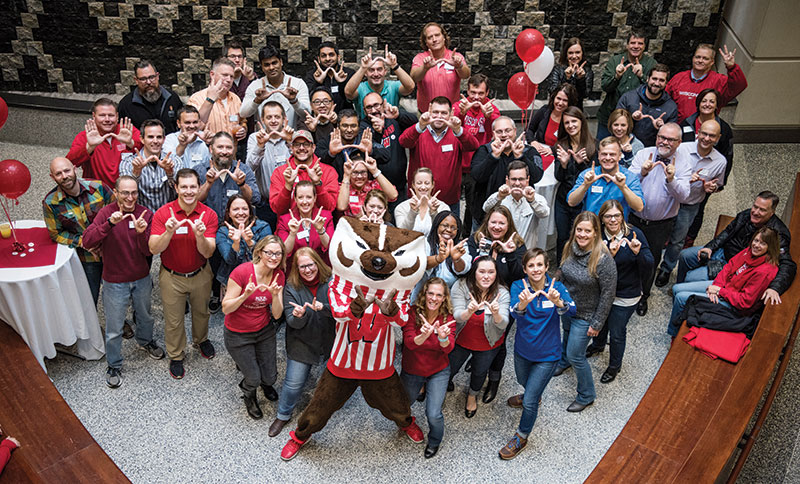 Bucky Badger and participants in the WSB Homecoming Bash flash the 'W' sign