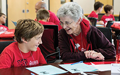 An elderly woman and a young boy share a laugh during the WSB Grandparents University event