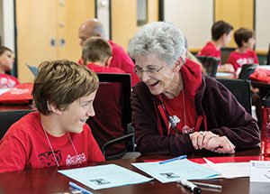 An elderly woman and a young boy share a laugh during the WSB Grandparents University event