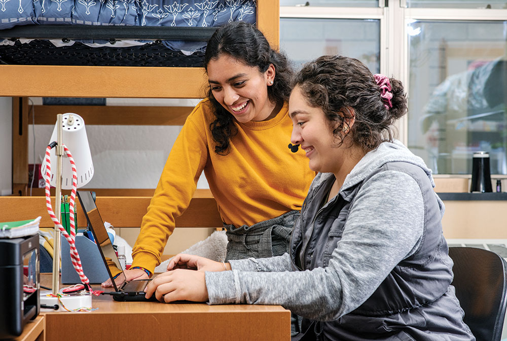 Roommates Jaqueline Sanchez and Hannah Brennan look at a laptop