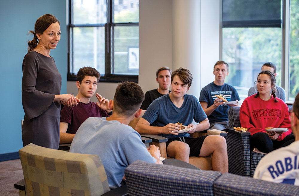 A group of students listens to instructor Laurel Bastain