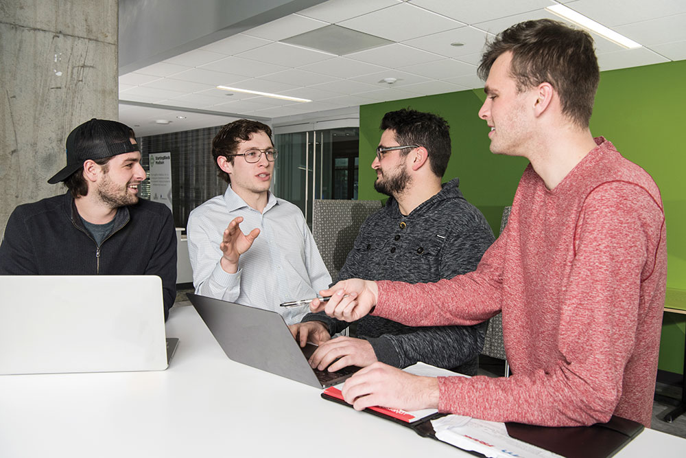 Max Fergus talks with three of his LÜM employees